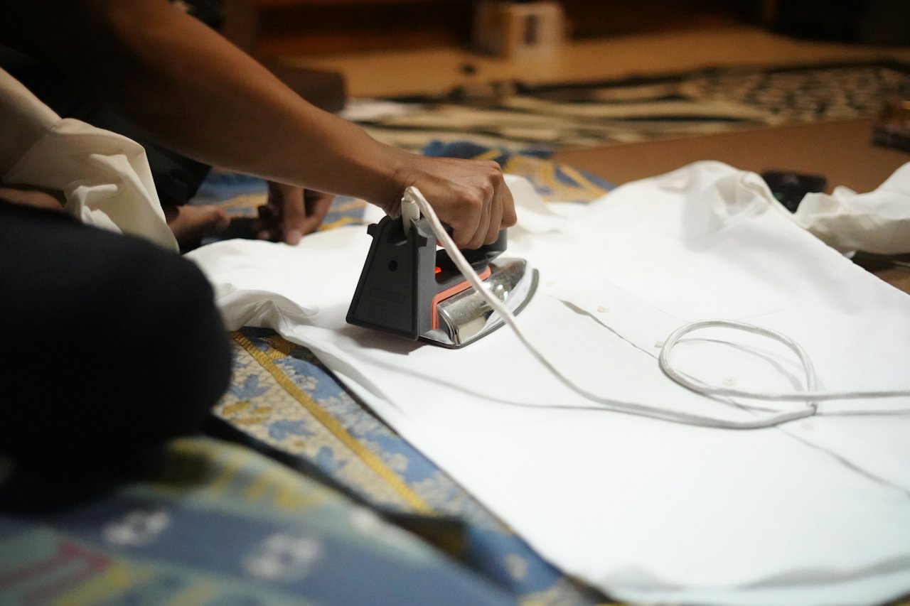 Person using an iron on a white T-shirt